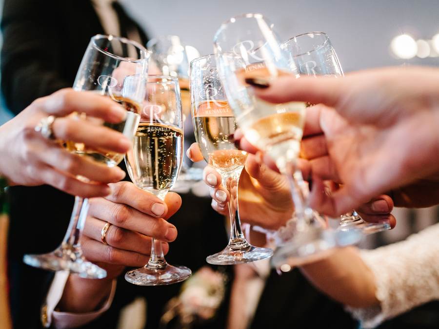 Guests raising glasses of estate wine at a VIVÂMEE holiday party in New Jersey